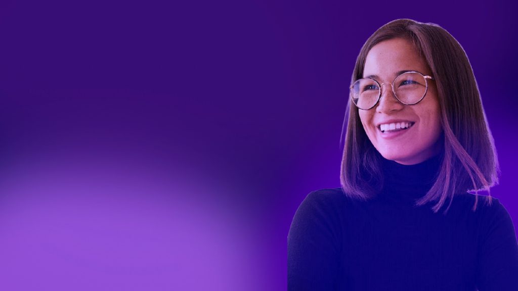 Mujer joven con gafas sonriendo sobre un fondo degradado morado